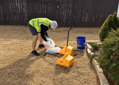 Poop Free OKC technician bagging dog waste after yard cleanup.