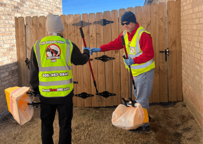 Poop Free OKC technicians entering a residential backyard to provide professional pet waste removal service in El Reno, Oklahoma.