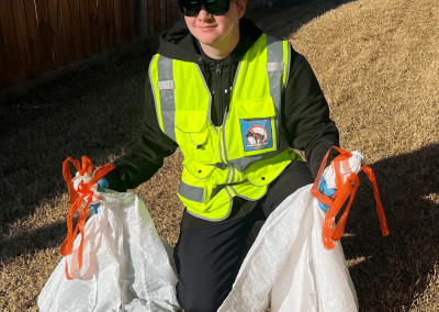 Poop Free OKC scoop technician Caiden removing dog poop during professional pet waste removal service in a residential yard in Yukon, Oklahoma.