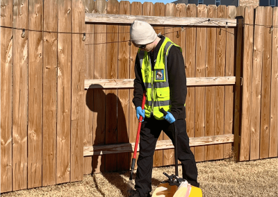 Poop Free OKC scoop technician Caiden providing professional pet waste removal in a residential backyard in El Reno, Oklahoma.