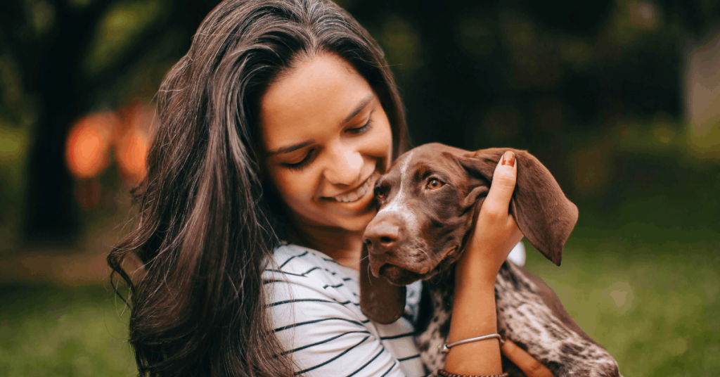 How to Tell If Your Dog Loves You | PoopFreeOKC.com Happy dog looking at its owner with soft eyes as a sign of love and trust.